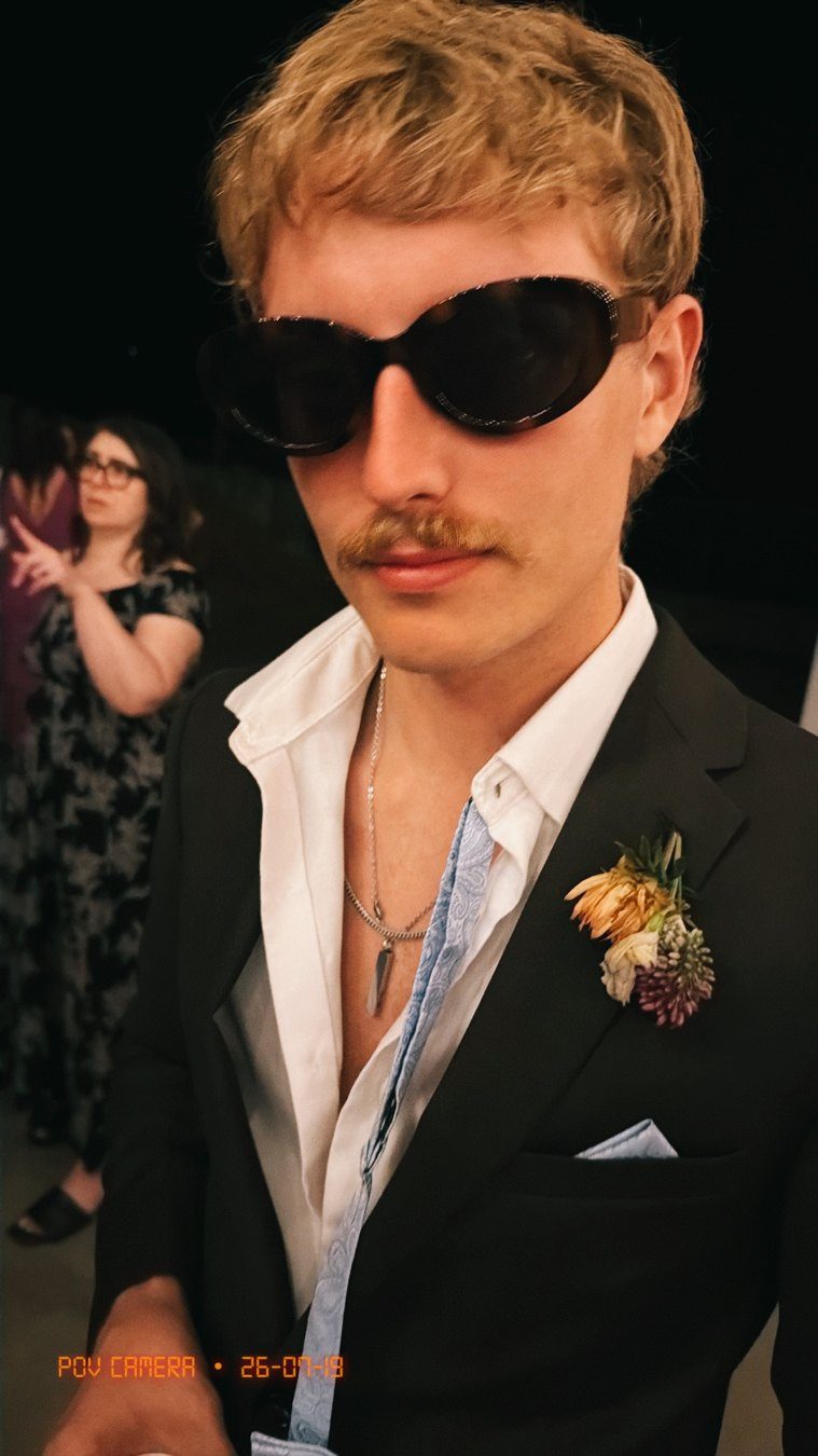 Chace Cade in a black suit and sunglasses at a formal event