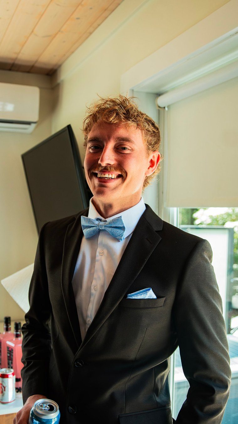 Chace Cade smiling in a black suit and blue bow tie