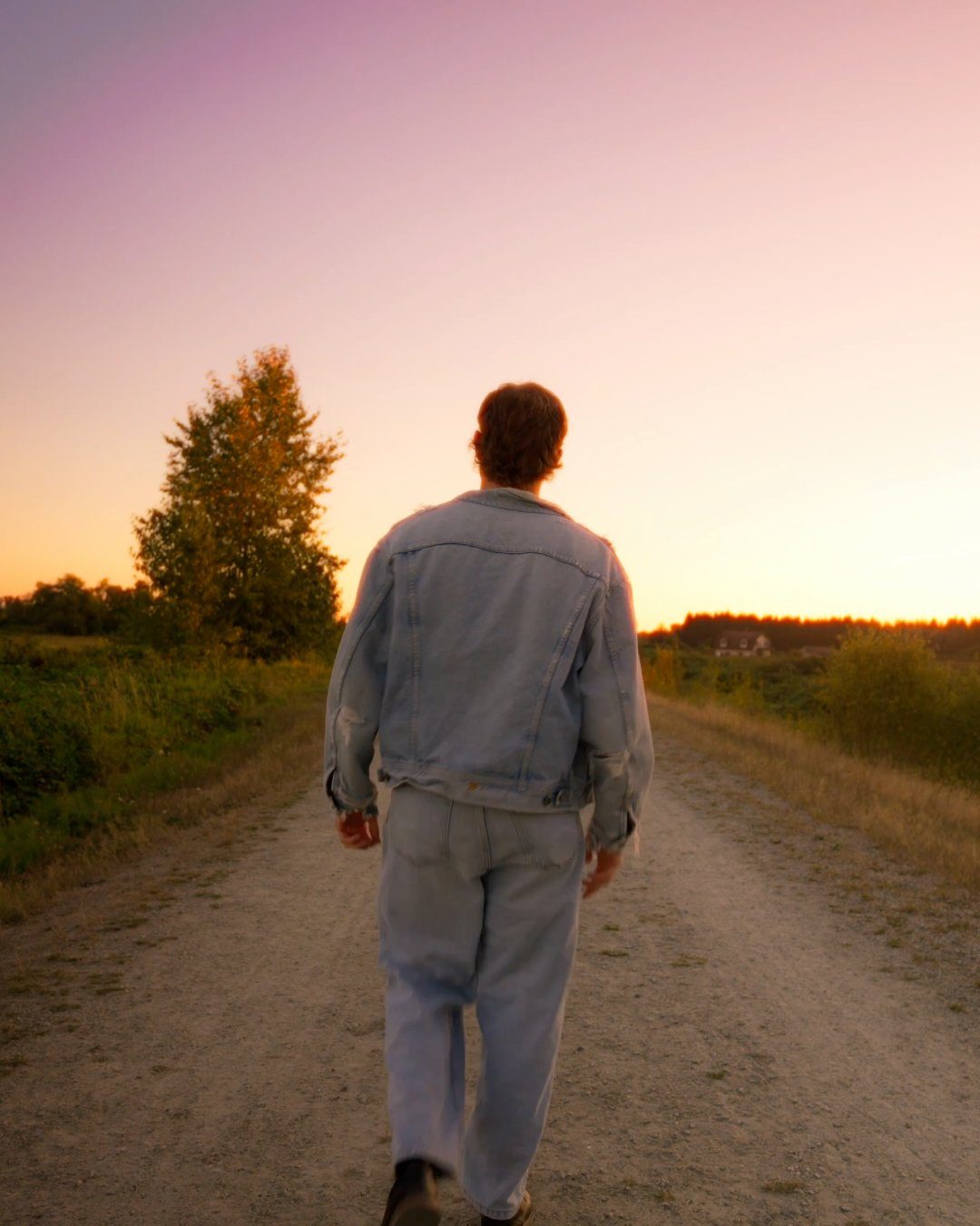 Chace Cade walking away down a country road at sunset