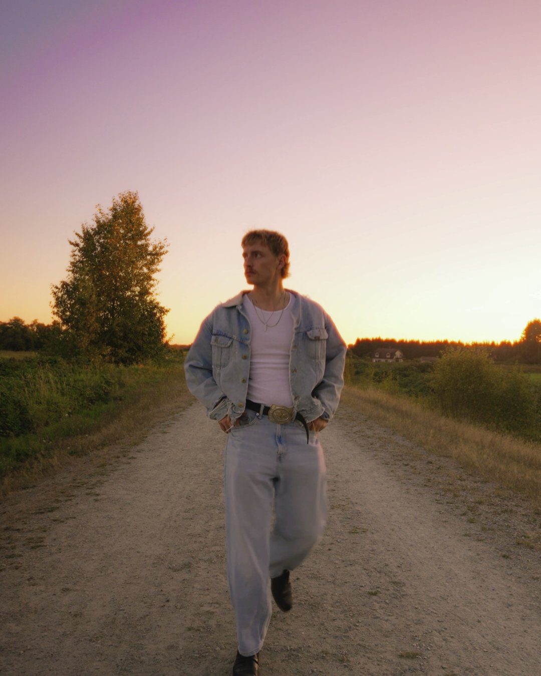 Chace Cade walking a gravel road at golden hour
